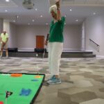 Senior woman playing mini golf